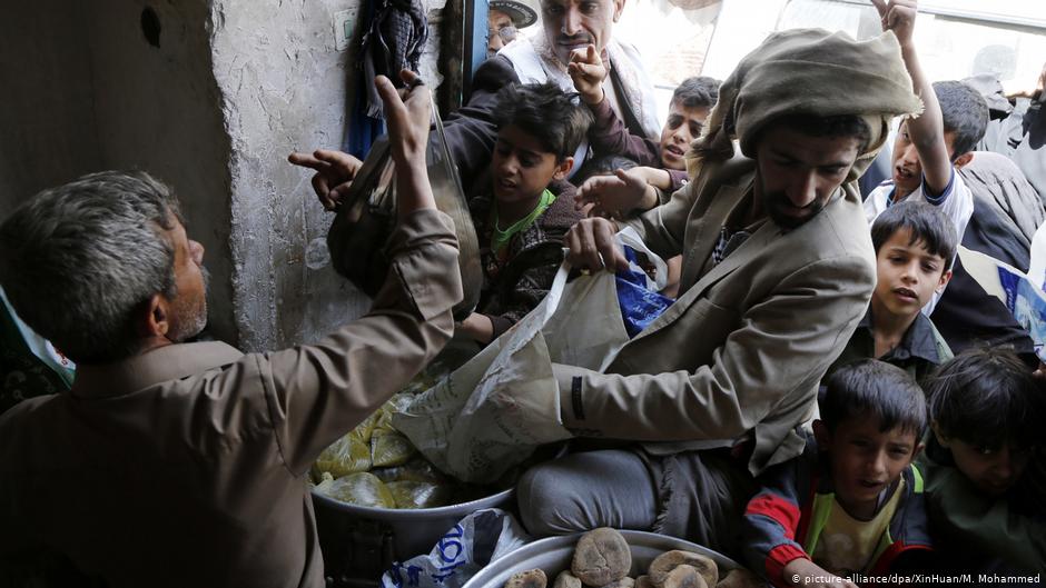 Yemenis collect food handouts at a distribution centre in Sanaa (photo: picture-alliance/dpa)