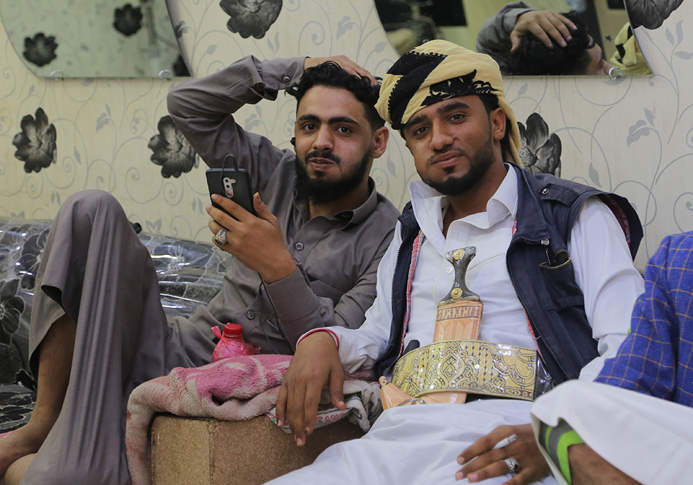في مدينة مأرب بِـ اليمن - شابان يمنييان يمضغان القات (وهو نبتة منشّطة أشبه بالكوكا) في صالون حلاقة محلّي. (photo: Ahmed Nagi)