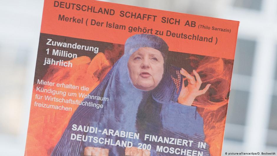 Ein Anhänger der Partei Alternative für Deutschland (AfD) hält am 31.10.2015 in Hamburg mit einem Schild gegen den Islam und Kanzlerin Angela Merkel; Foto: picture-alliance/dpa/D. Bockwoldt