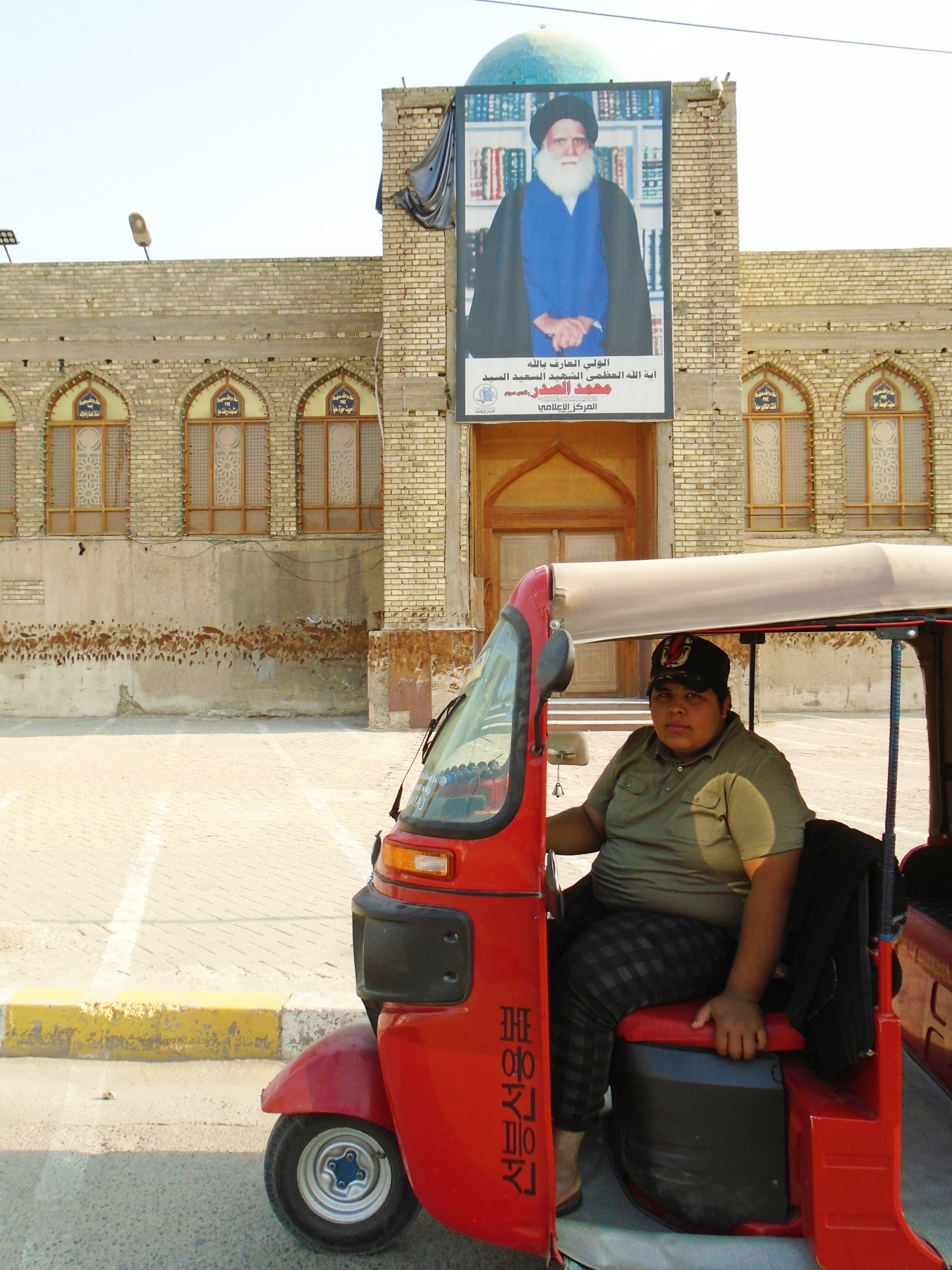 Hussein in his bright red tuk-tuk in Sadr City (photo: Birgit Svensson)