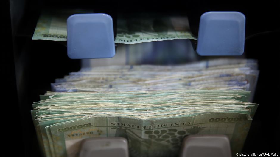 عَدُّ نقود بالعملة اللبنانية على آلة في أحد محلات صرف العملات في بيروت - لبنان.  (photo: AP Photo/Hussein Malla)