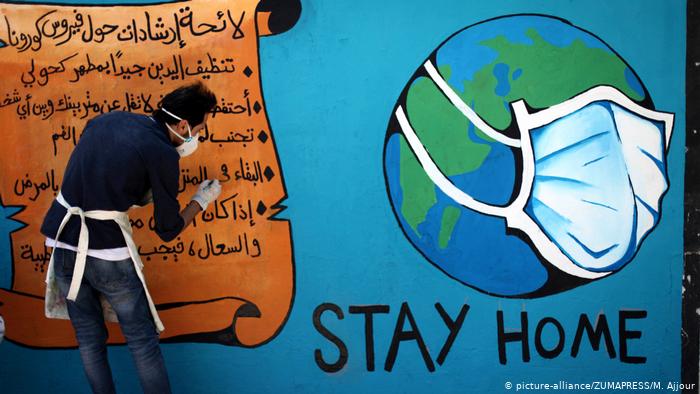 A Palestinian artist draws a "stay home" mural as part of an awareness-raising campaign about the spread of coronavirus (photo: picture-alliance/ZUMAPRESS/M. Ajjour)