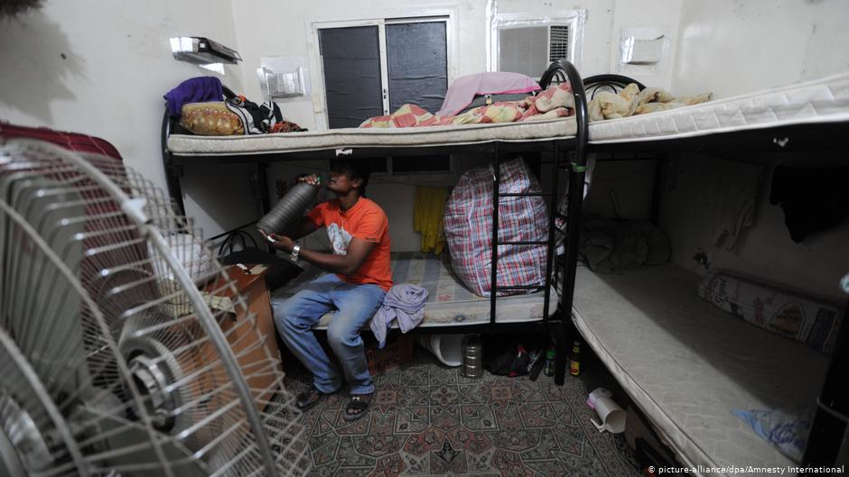 Ein Wanderarbeiter sitzt auf einem Etagenbett in seiner Unterkunft in Qatar; Foto: dpa