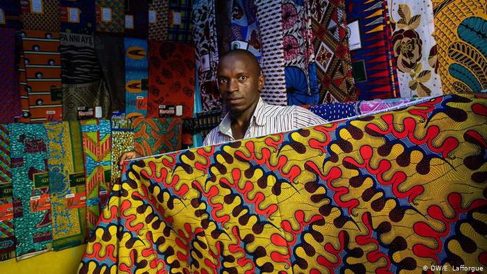 A man holds a traditional Ivorian wax print fabric (photo: DW/E. Lafforgue)