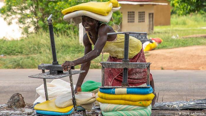 An Ivorian woman from the Femmes Battantes Cooperative wraps attieke - traditional couscous - in bags (photo: DW/E. Lafforgue)