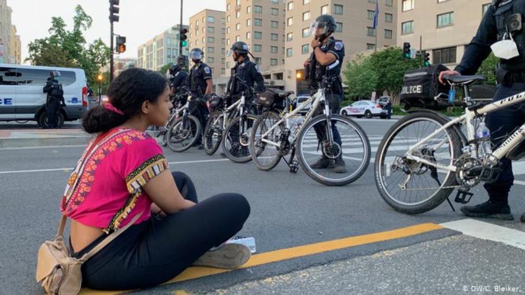 Demonstrantin Deborah sitzt in DC vor einer Reihe Polizisten (DW/C. Bleiker.)