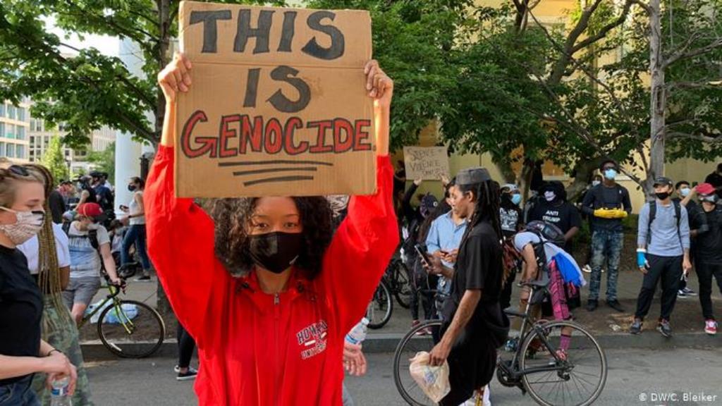 Demonstrantin Mya hält in DC ein Schild hoch auf dem This is genocide steht. (DW/C. Bleiker)