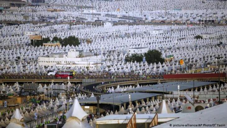 Muslim pilgrims walk back to their tents during the annual hajj pilgrimage on the first day of Eid al-Adha in Mina, 2018 (photo: picture-alliance/AP/D. Yasin)