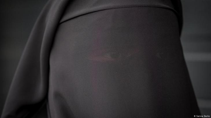 Eine Frau in einem leeren Tunnel in Amsterdam mit einer schwarzen Burka; Foto: Sanne Derks