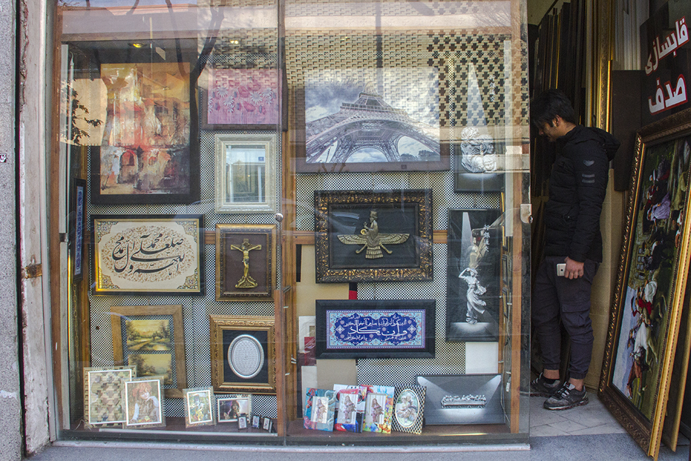 A Christian cross, a Zoroastrian symbol of Faravahar and calligraphy by Ayatul Kursi from the Koran on display together in a picture-framing shop (photo: Changiz M. Varzi)