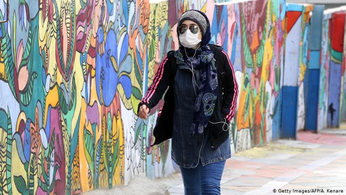 إيرانية تمشي وعلى وجهها قناع واقٍ من فيروس كورونا. Foto: AFP/Getty Images
