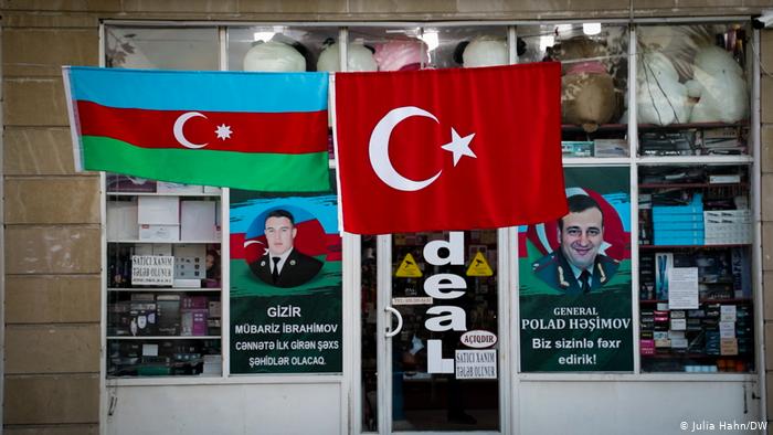 Turkish and Azerbaijani flags in front of a business with propaganda posters in the windows (photo: Julia Hahn/DW)