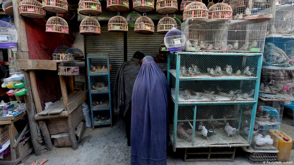 Eine Afghanin in Burka steht vor einem Laden auf dem Vogelmarkt Ka Faroshi in Kabul, Afghanistan. Foto: REUTERS/Mohammad Ismail