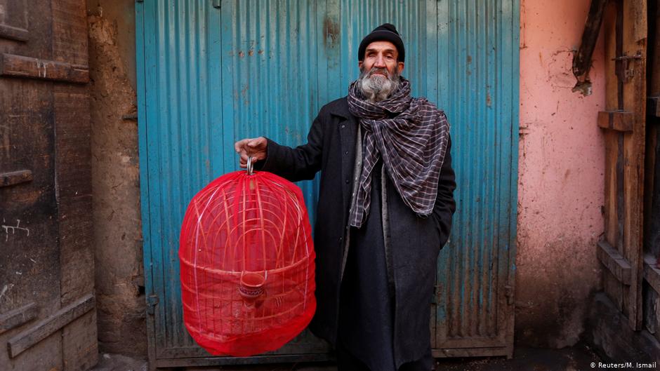 Fatih, 70, hält einen Käfig mit Rebhühnern in der Hand, während er für ein Bild auf dem Vogelmarkt Ka Faroshi in Kabul, Afghanistan, posiert. Foto: REUTERS/Mohammad Ismail
