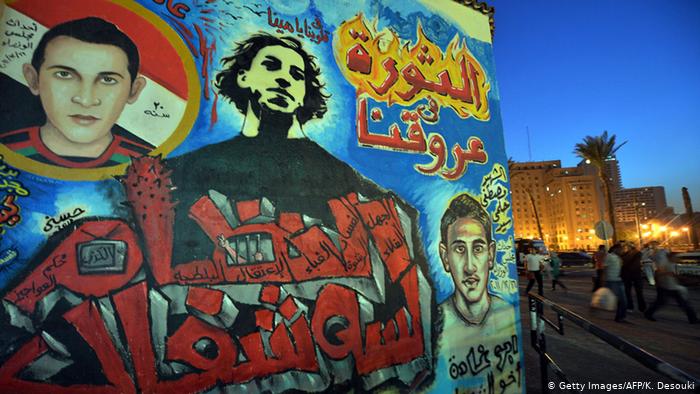 A mural showing young men and a slogan in Arabic (photo: Getty Images/AFP/K. Desouki))