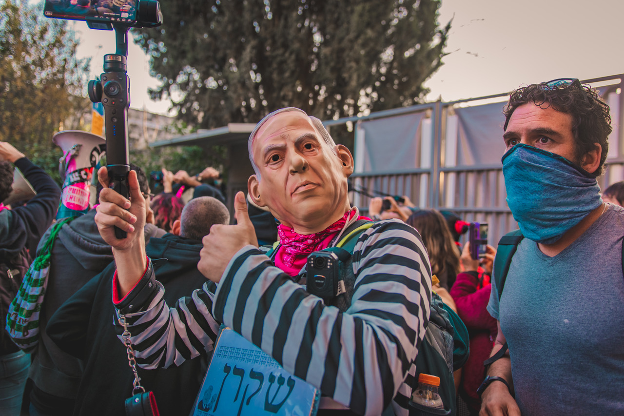 Ein Demonstrant verkleidet als Häftling Netanyahu bei den Protesten in der Balfour-Straße in Jerusalem, Januar 2021. Auf dem Plakat steht: "Lügner"; Foto: Khalil Myroad