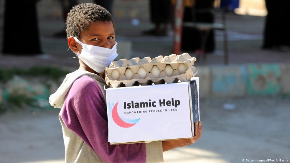 طفل يمني ذو أصل إفريقي يحمل مساعدات غذائية في مدينة تعز - اليمن. Foto: Getty Images/AFP/A.Al-Basha
