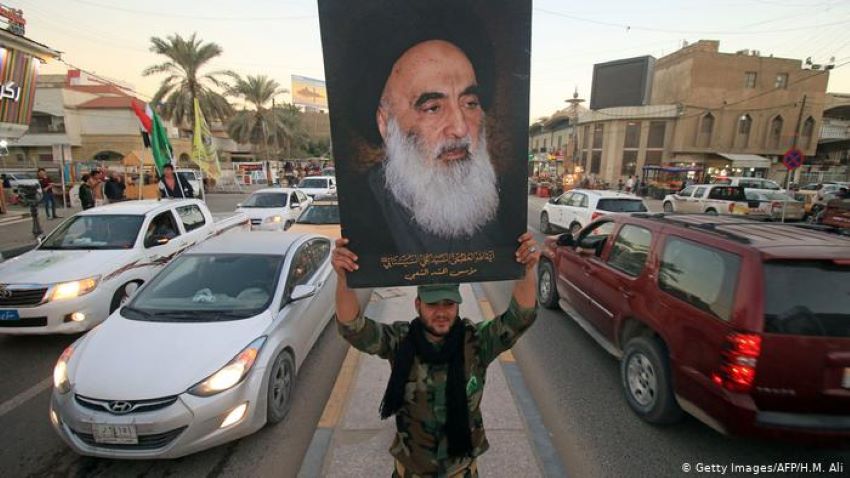 A member of the Hashed al-Shaabi, or Popular Moblization Units, carries a picture of Sistani during victory celebrations in December 2017 after Iraq declared Islamic State defeated (photo: Getty Images/AFP/H. M. Ali)