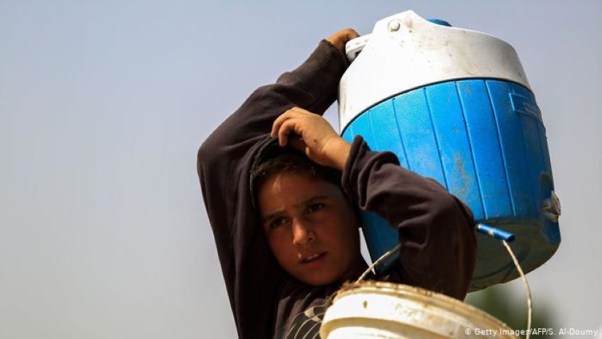 A Syrian boy carries water in a container (photo: Getty Images/AFP/S. Al-Doumy)
