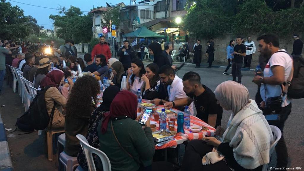 Palästinenser und jüdische Siedler stehen sich während des abendlichen Fastenbrechens gegenüber. (Foto: Tania Kraemer/DW)