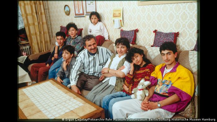 A family of eight sitting on a sofa