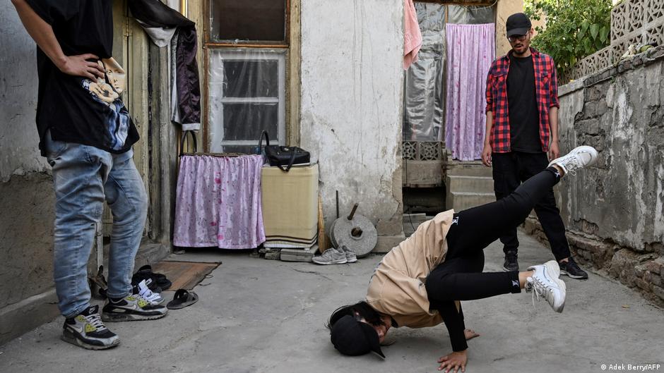 Manizha Talash (centre), the only female member of a group of breakdancers comprised of mostly Hazara boys, practices a move as two members of her troupe look on in Kabul (photo: Adek Berry/AFP)