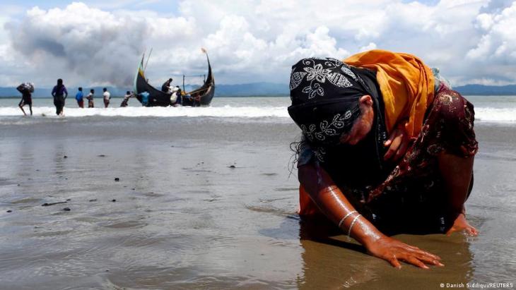 Eine erschöpfte Rohingya-Frau berührt den Boden der Küste, nachdem sie die Grenze zwischen Myanmar und Bangladesch am Golf am 11. September 2017 mit dem Boot in Shar Powrir Dip im Golf von Bengalen überquert hat; Foto: REUTERS/Danish Siddiqui