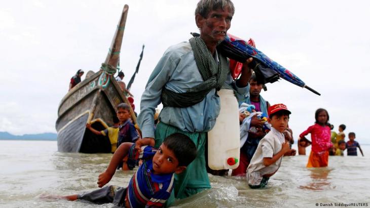 Ein Rohingya-Flüchtling zieht ein Kind mit sich, während sie in Richtung Küste laufen, nachdem sie die Grenze zwischen Myanmar und Bangladesch am Golf am 10. September 2017 mit dem Boot in Shar Powrir Dip im Golf von Bengalen überquert haben; Foto: REUTERS/Danish Siddiqui