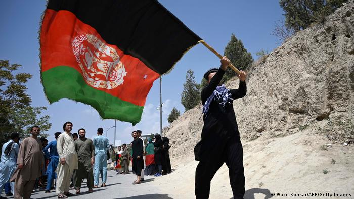 Afghane schwenkt eine große afghanische Landesfahne