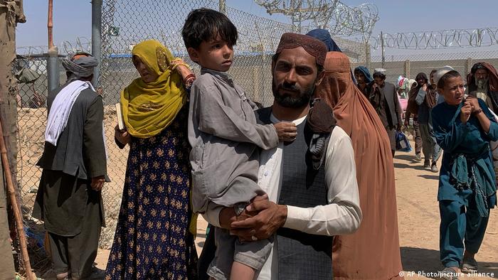 Ein Mann trägt einen kleinen Jungen am Grenzübergang Spin Boldak/Chaman