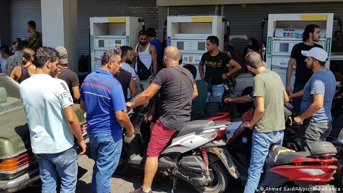 Men wait at a petrol station in Lebanon.