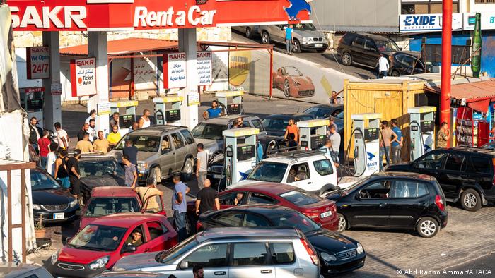 People and many cars wait at a petrol station in Lebanon.