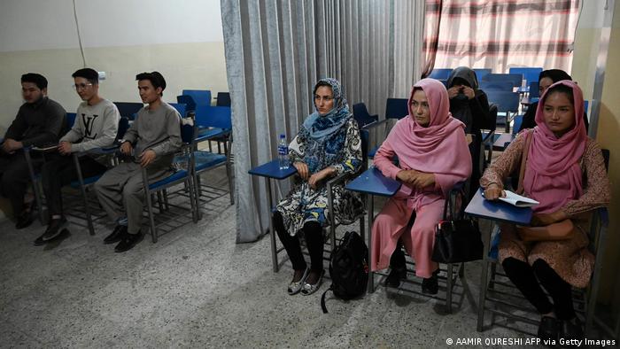 Students attend a class divided by a curtain separating males from females at a private university in Kabul on 7 September 2021