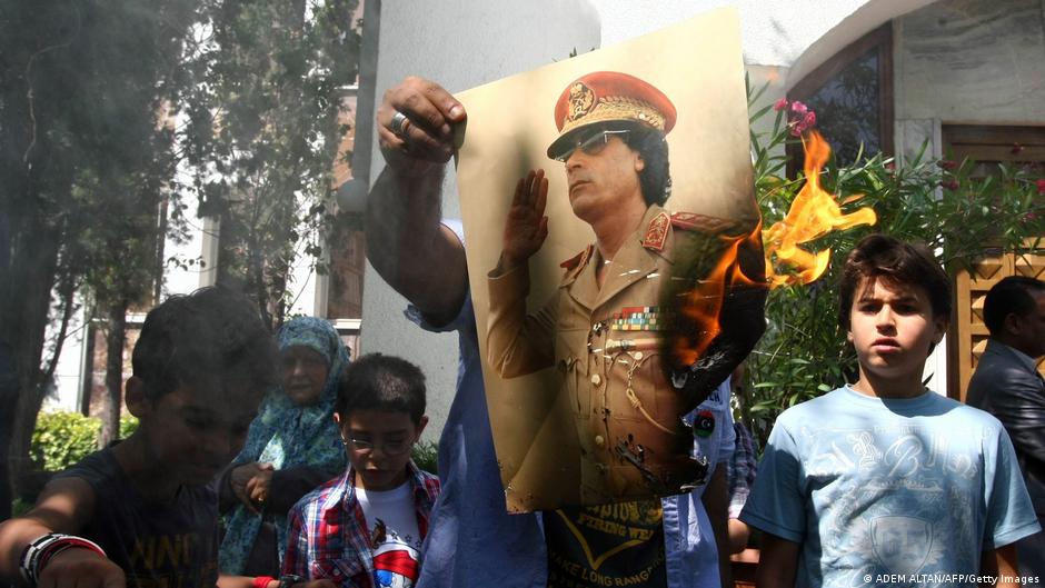 Demonstranten setzen 2011 ein Plakat mit dem Gesicht des libyschen Diktators Muammar Gaddafi in Brand; Foto: AFP/Getty Images