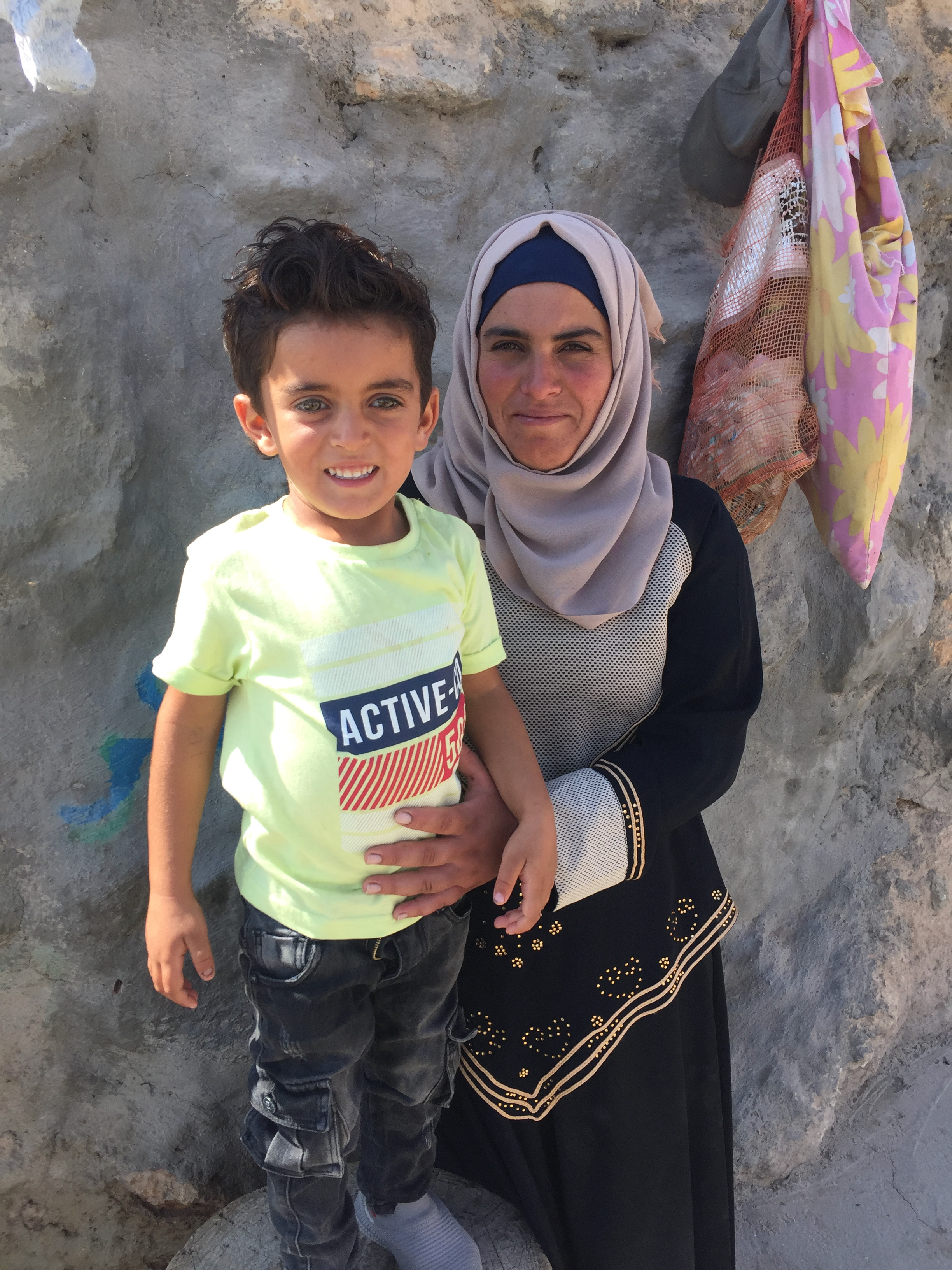 Der dreijährige Muhammad Bakr Hussein mit seiner Mutter Bara’a Hamandi vor dem Haus der Familie in dem Dorf Mufkara im Westjordanland; Foto: Inge Günther