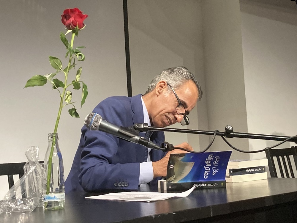 Jalal Barjas signs copies of his award-winning novel "Notebooks of the Bookseller" at the Berlin International Literature Festival symposium in September 2021 (photo: Rim Najmi)