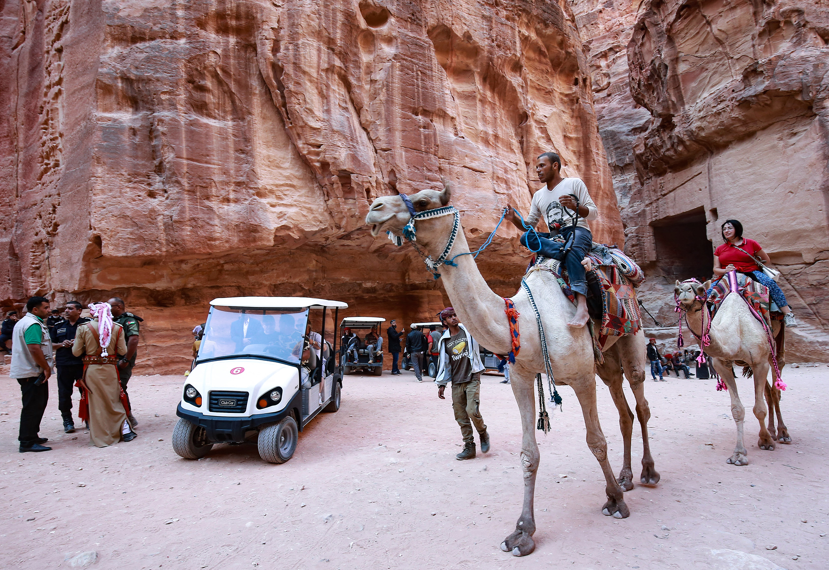 Tourists ride camels and others an electric cart, during their trip to Jordan‘s famed ancient city of Petra, some 230km (143 miles) south of the capital Amman, on 27 October 2021 (photo: Khalil Mazraawi/AFP) -