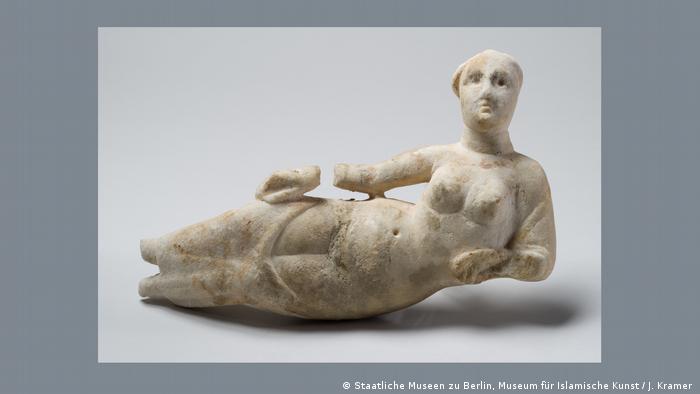 Eine weiblich Gottheit aus Alabaster liegt auf der Seite, Hände und Füße abgebrochen, nur mit einem Tuch um die Beine bekleidet, die Vulva liegt frei.