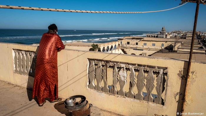 A man looking over the rooftops of Guet Ndar, a neighbourhood on Langue de Barbarie