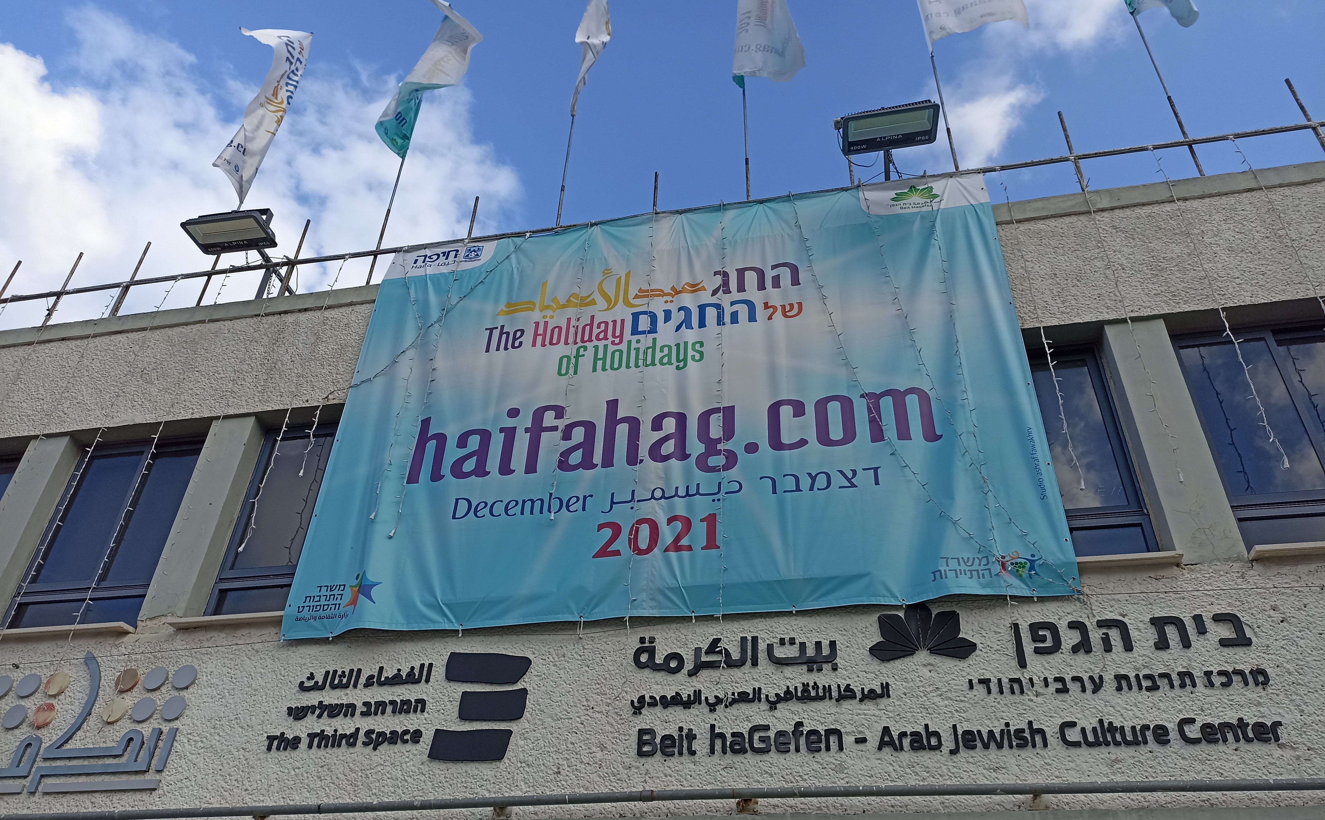 Banner advertising Haifa's Holiday of Holidays on the facade of Beit Hagefen – Israel's only cultural centre specifically dedicated to joint Jewish-Arab dialogue (photo: Noam Yatsiv)