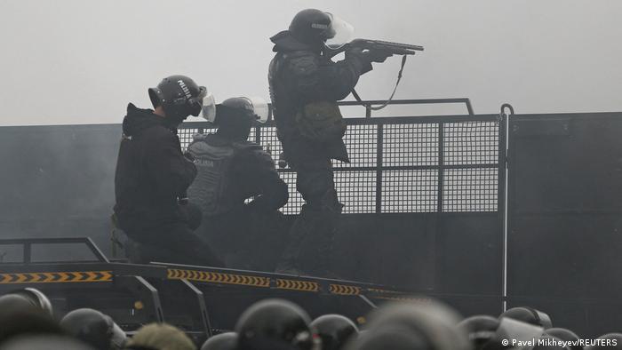 Ein Polizist mit Gewehr im Anschlag in Almaty