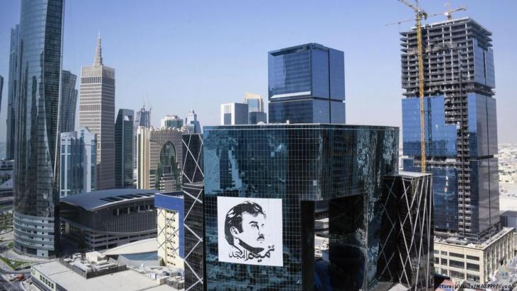 صورة من عاصمة قطر - الدوحة - تظهر فيها صورة ضخمة للأمير تميم بن حمد آل ثاني. Doha skyline with an oversized image of Emir Tamim bin Hamad al-Thani (photo: picture-alliance)