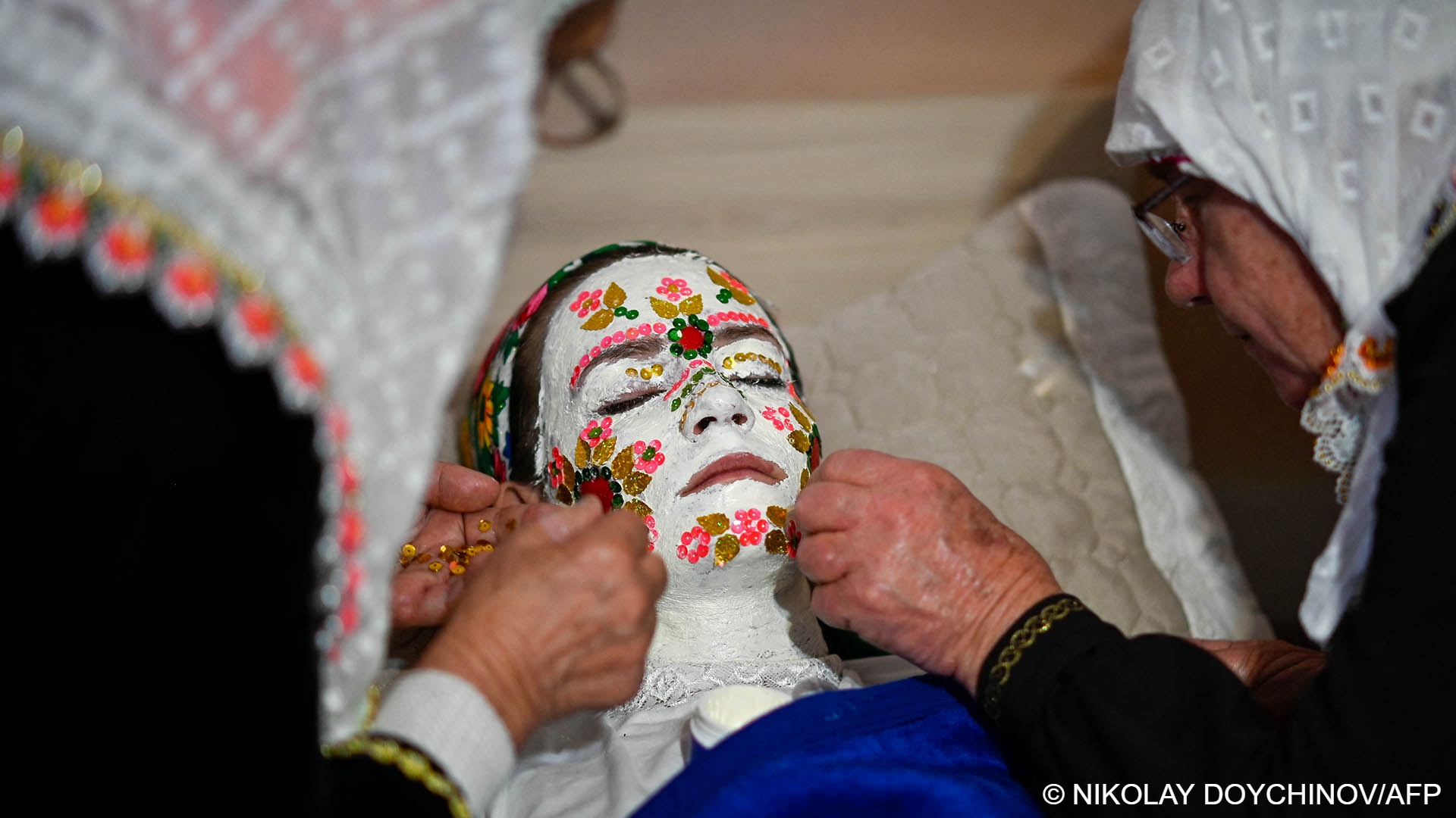 Female relatives apply special make-up to the Pomak bride-to-be (photo: Nikolay Doychinov/AFP)
