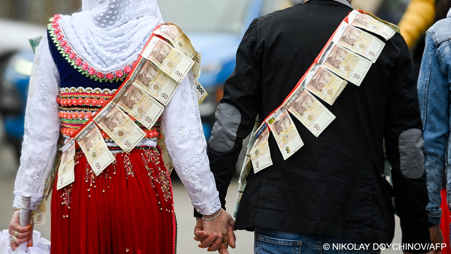 A Pomak couple walk hand-in-hand, proudly displaying the bride's dowry (photo: Nikolay Doychinov/AFP)