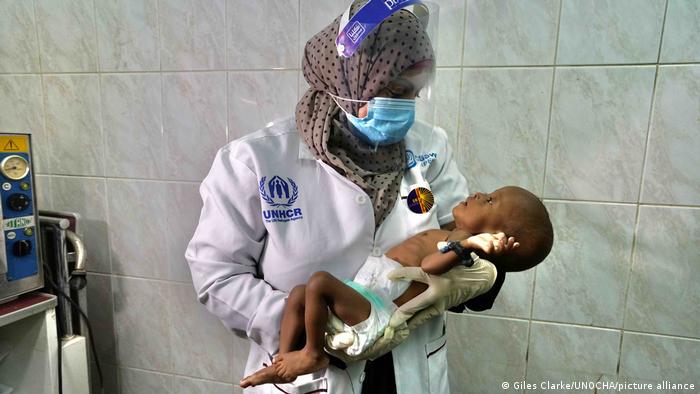 A doctor holds a baby in Yemen