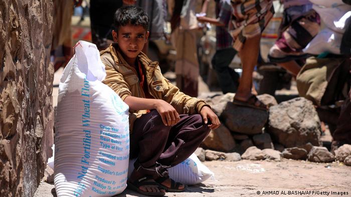 A Yemeni boy receives humanitarian aid, donated by the World Food Programme (WFP), in the country's third city of Taez