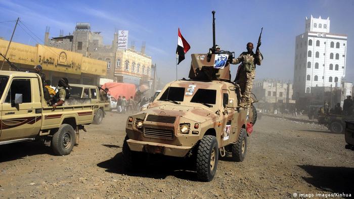 Bewaffnete Kämpfer stehen auf einem gepanzerten Fahrzeug, während sie an einer Versammlung in Sanaa, der Hauptstadt des Jemen, teilnehmen