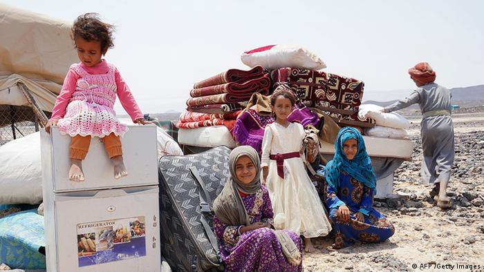 Vertriebene jemenitische Kinder sitzen neben ihren Habseligkeiten