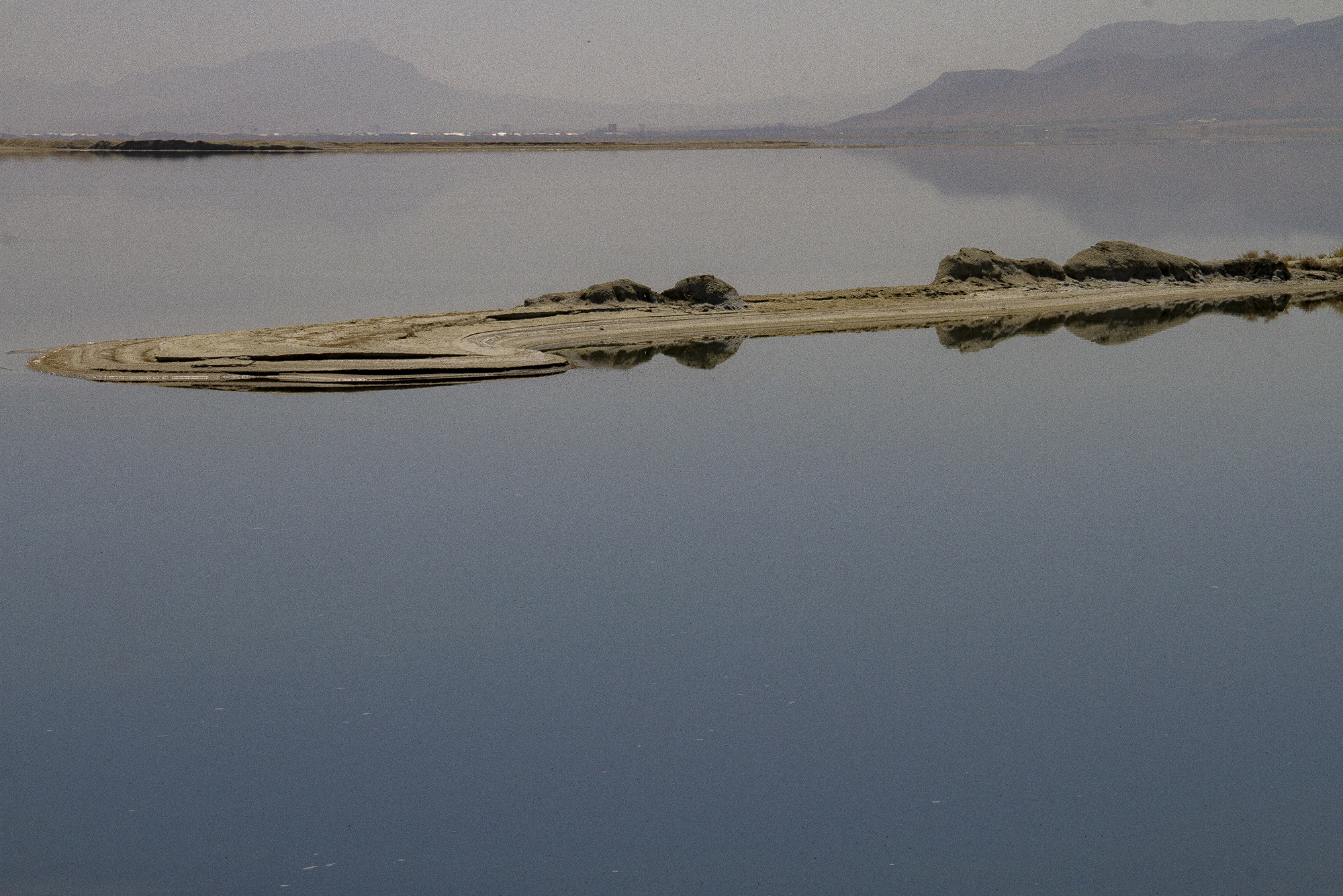 Blick auf einen See, mit Bergen im Hintergrund und einer Insel in der Mitte (Foto: Qantara)