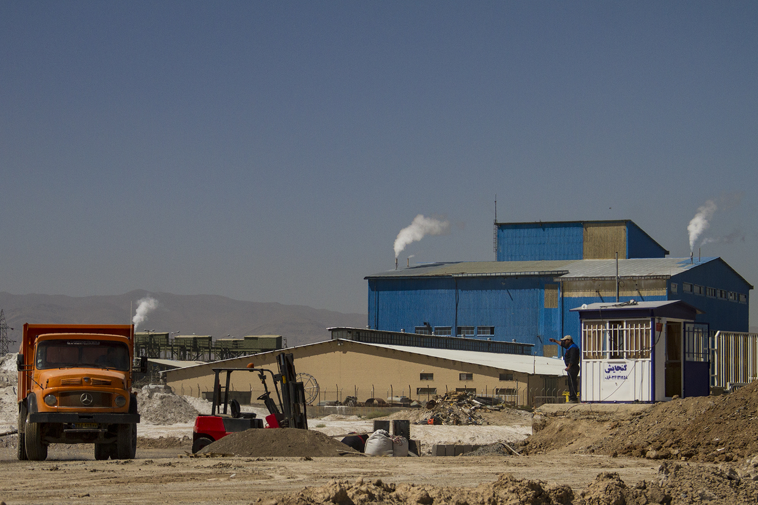 Blick auf eine Industrieanlage, trockener Vordergrund (Foto: Qantara)
